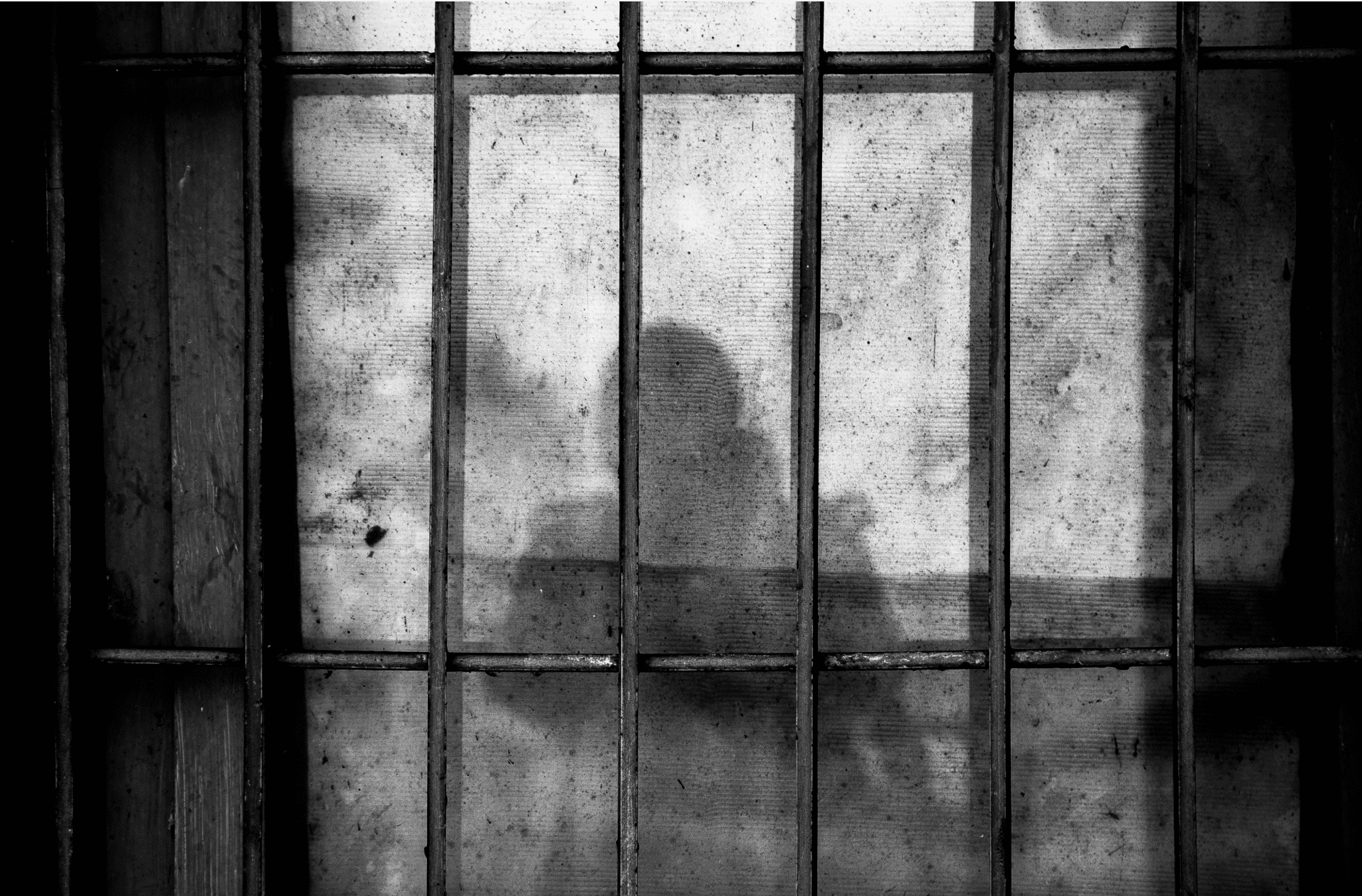 Image of a human shadow on a prison cell wall